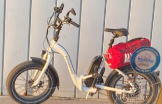 Electric bike with a red cargo bag, &quot;Dad Power Bikes&quot; text on frame, &quot;Arro&quot; on tire
