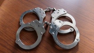 Silver handcuffs on a wooden surface