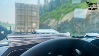 Stack of documents on a dashboard, blurry buildings in background