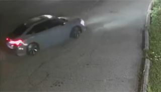 Black car parked on a wet road.