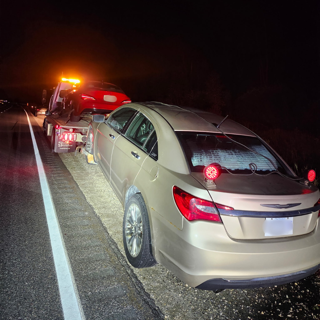 Damaged tan sedan on a tow truck.