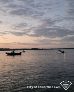 Several boats on a calm lake at dusk.