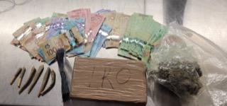 Canadian currency and a pile of small baggies, possible drugs.