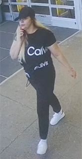 Person in black t-shirt and leggings, white sneakers