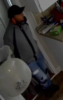 Person in dark clothing and a hat, unclear.