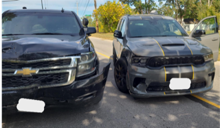 Black Chevrolet Tahoe and Dodge Charger parked facing each other
