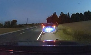 Stationary vehicle with flashing blue and red lights.