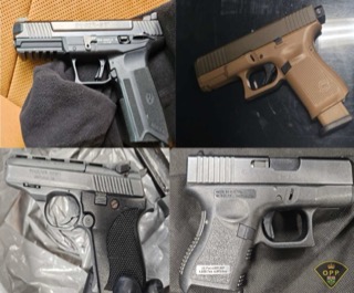 Two handguns, one black and one tan, on a black surface.