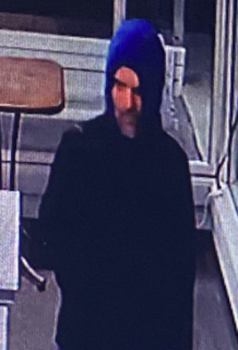 Person wearing a blue knit hat and dark jacket