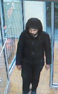 Person wearing a dark hooded jacket and pants