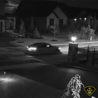 Dark car parked on a driveway, blurred image.
