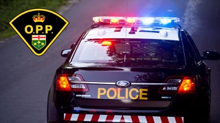 Police cruiser with lights activated. O.P.P. emblem.