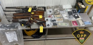 Firearms and cash displayed on a metal table.
