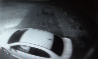 Blurred image of a car windshield with rain streaks.