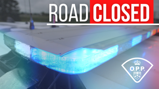 Road closed. OPP crest. Blue and red flashing lights.