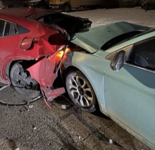 Two cars, red and green, collided, front ends damaged