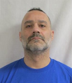 Man with shaved head and graying beard, blue shirt