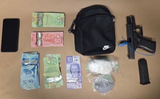 Canadian currency and a handgun arranged on a surface.