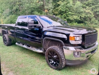 Black pickup truck with lifted suspension and large tires