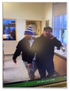 Two people standing near a counter.