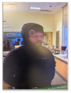 Person wearing a black beanie and glasses