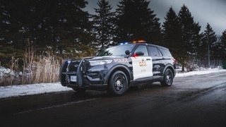 Police SUV parked on a snowy road.