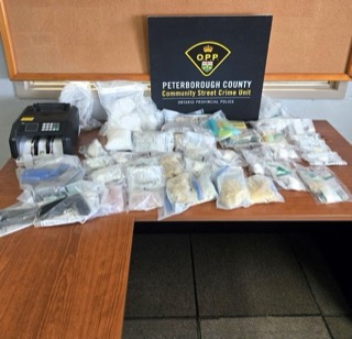 Large quantity of drugs and paraphernalia on a table.