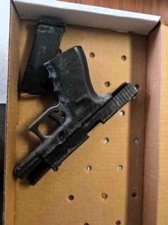 Black handgun in a holster inside a cardboard box