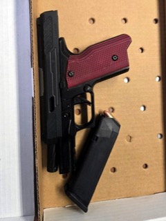 Black pistol with red grips and a magazine.