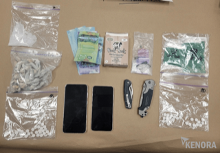 Small baggies of white powder, Canadian twenty and ten dollar bills, a pocket knife, and a small package labeled &quot;Stink Sack&quot;