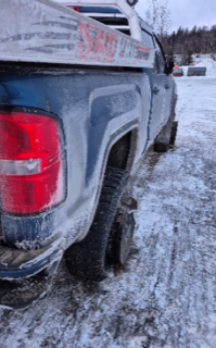 Blue pickup truck covered in ice and snow.
