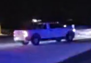 Blue pickup truck parked on a dark street