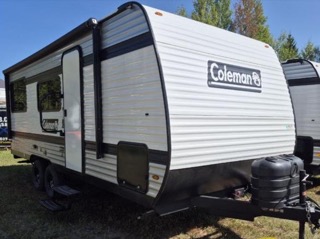 White travel trailer with black accents and Coleman logo