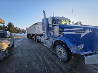 Blue Kenworth truck with a white trailer.