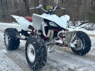 White and red ATV covered in snow