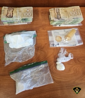 Canadian currency and white powder in plastic bags.