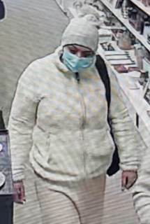 Person wearing a light-colored puffer jacket and matching pants, face mask, and a knit hat.