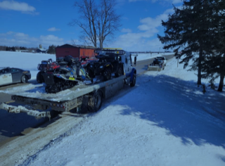 Snowmobile on a flatbed tow truck, snowy landscape