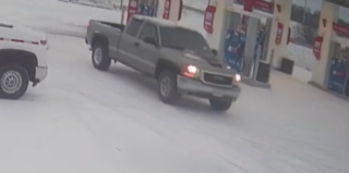 Gray pickup truck at a gas station