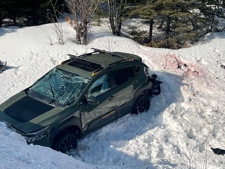Green SUV stuck in snow, windshield cracked
