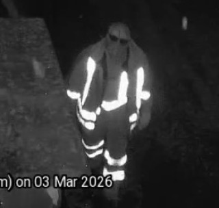 Person in reflective clothing, partially obscured by darkness.