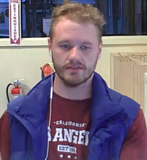 Man with short red hair and a blue vest, wearing a red shirt that reads &quot;California Angels Est. 1903&quot;