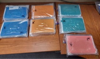 Six blue and orange plastic bags on a wooden surface.