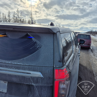 Black SUV with snow and ice covering the rear. Ontario Provincial Police emblem visible.