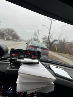 Dashboard with radar display showing 106 and 59, view of a road with trees