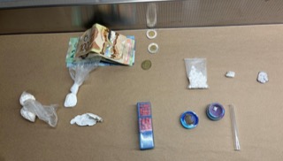Canadian currency and small baggies of white powder on a surface.