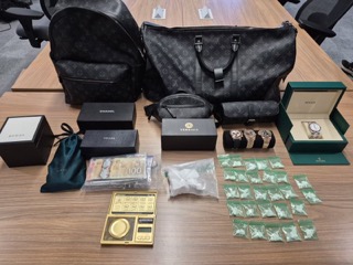 Luxury bags, watches, and cash on a surface