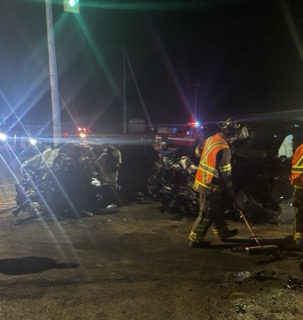 Wrecked car on the road, firefighters working