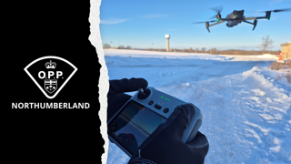 Drone flying over snow-covered field.