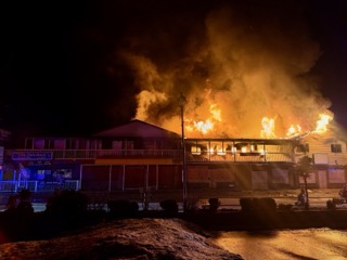 Building engulfed in flames, thick smoke rising.